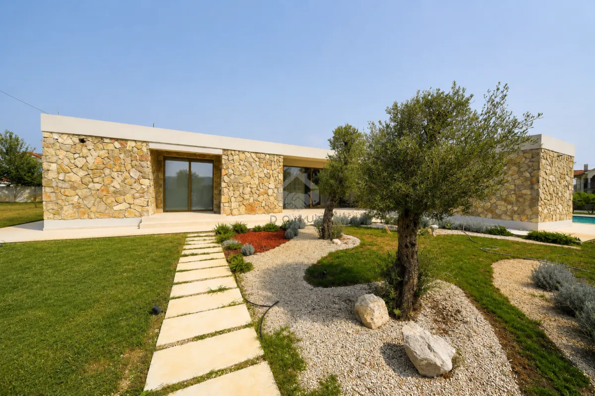 View of the exterior of the house with a landscaped yard and walkway.