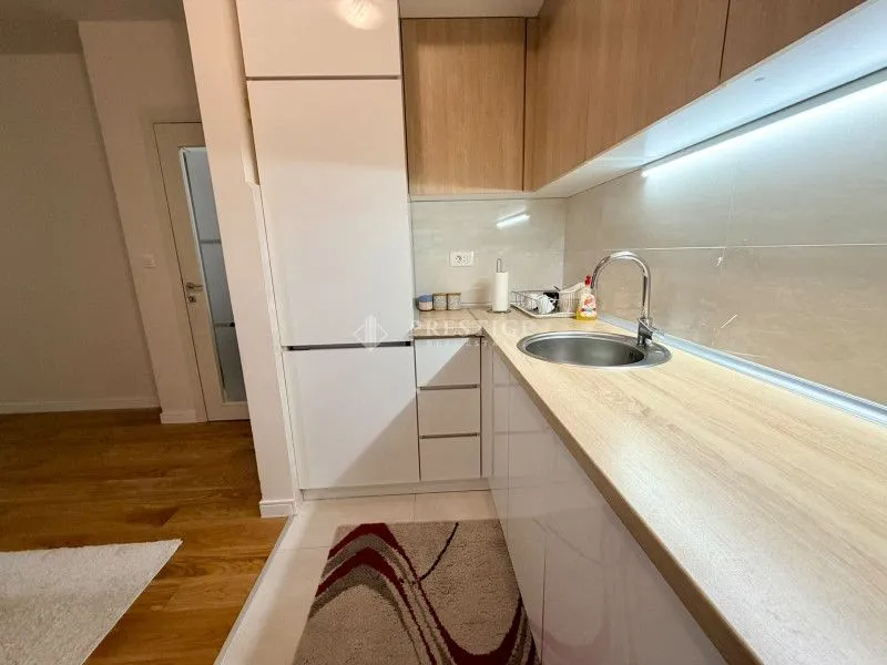 Modern kitchen with white cabinets and wooden countertops.