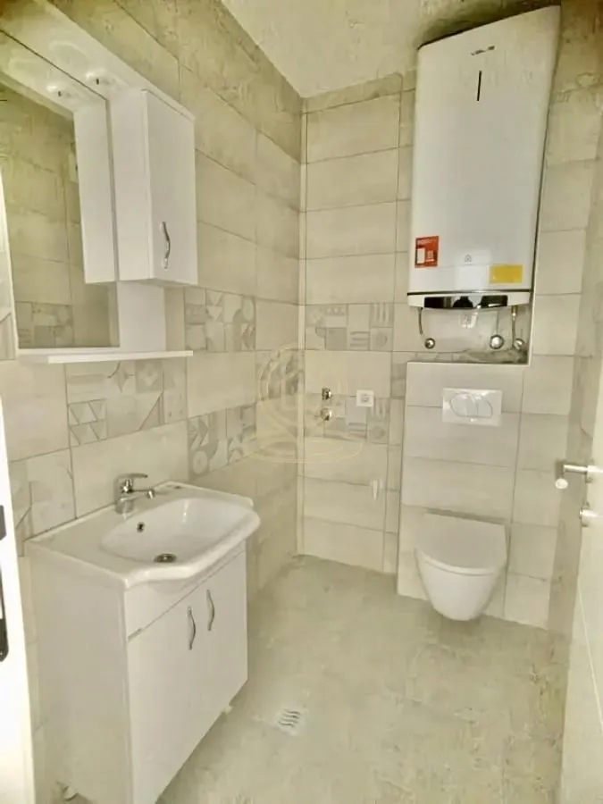 Manje kupatilo sa umivaonikom, WC šoljom i bojlerom.