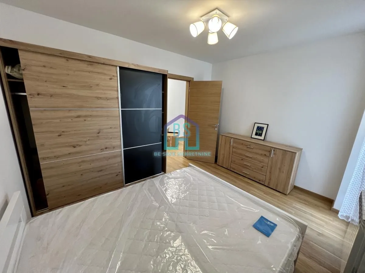 Furnished bedroom with a double bed, large wardrobe, and chest of drawers.