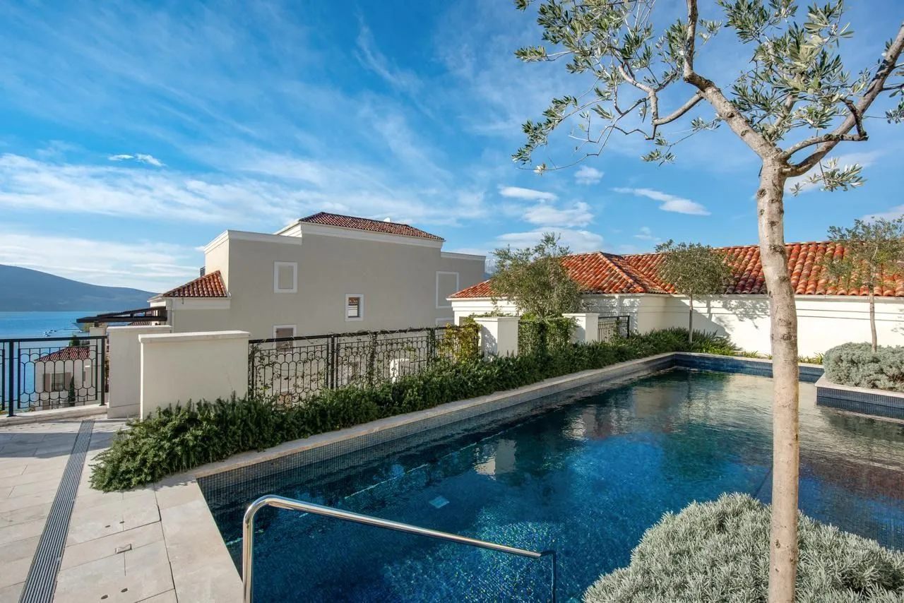 View of the outdoor swimming pool with a terrace and sea view.