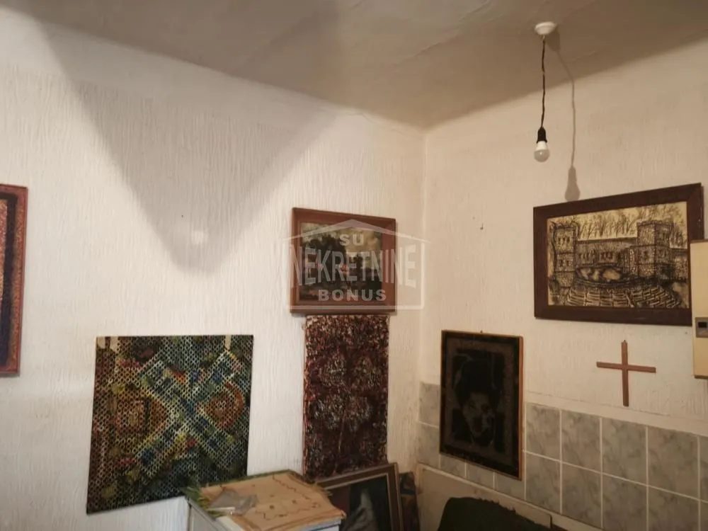 Detalj unutrašnjosti prostorije sa zidnim dekoracijama i slikama.