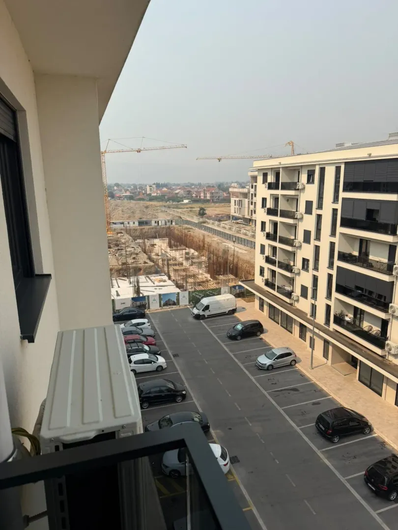 Pogled sa terase na parking i okolne zgrade u izgradnji.