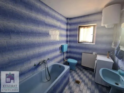 Kupatilo sa plavim pločicama, kadom, toaletom i veš mašinom. - image 20