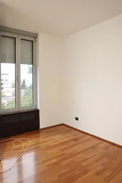 Empty room with hardwood floors and a window. - image 9