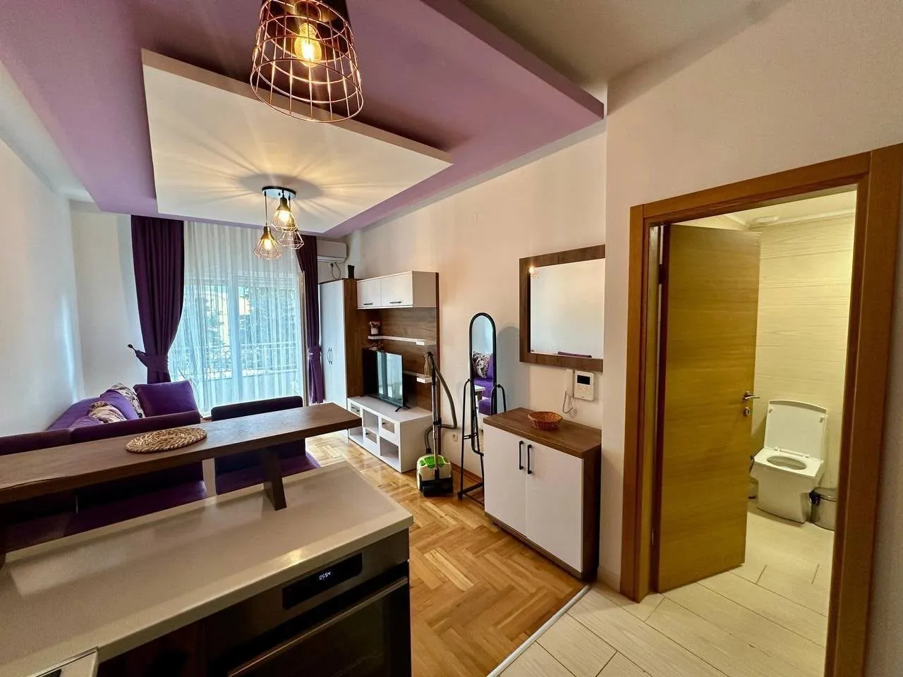 Living room connected to the kitchen with a view of the bathroom.