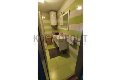 Kupatilo obloženo zelenim i belim pločicama sa umivaonikom i bojlerom. - image 14