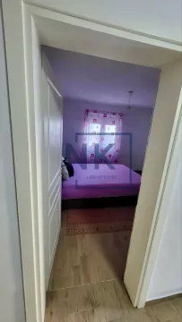 View from the hallway into a bedroom with a bed and a window. - image 4