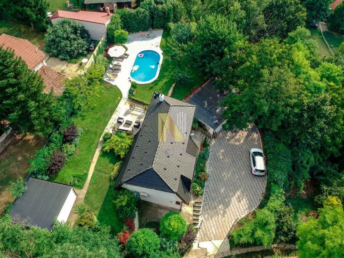 Pogled iz vazduha na kuću sa dvorištem, bazenom i zelenilom.