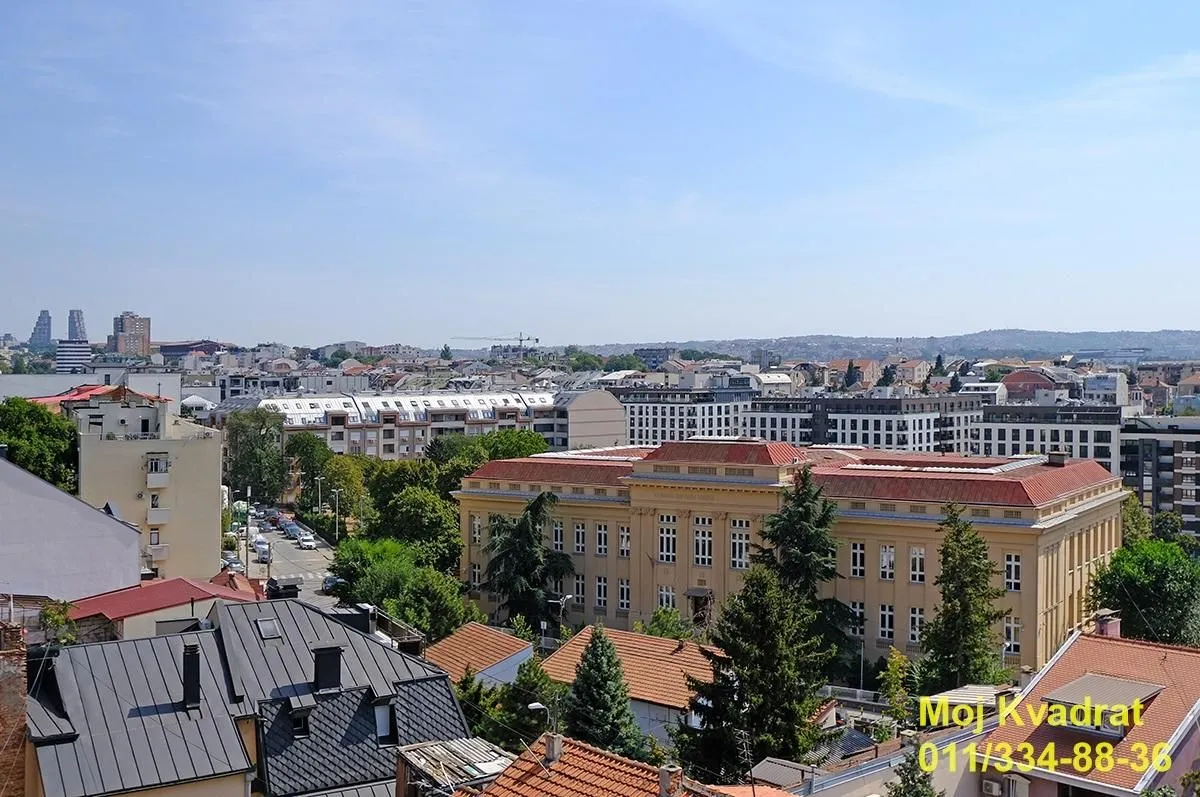 Pogled sa prozora na gradsko naselje i okolne zgrade.