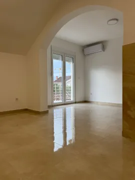 An empty, bright room with tiled flooring and access to a balcony. - image 10