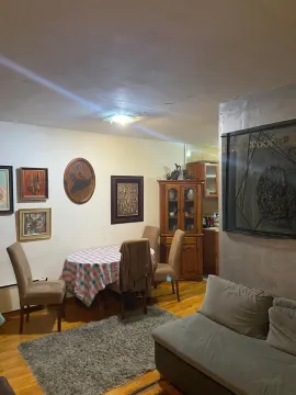 Dnevna soba sa trpezarijskim stolom, garniturom i umjetničkim slikama na zidovima. - image 2