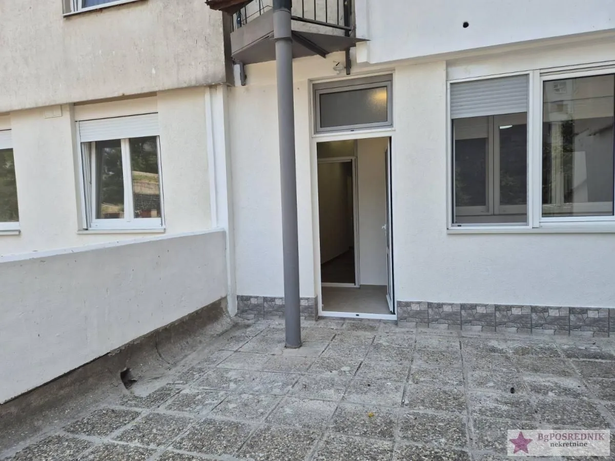 Terrace with an entrance door to the building and tiled flooring.
