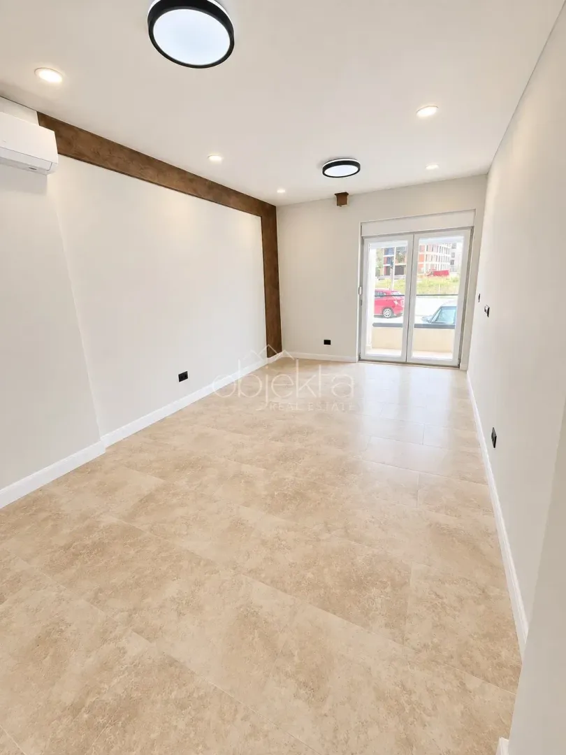 Empty bright room with tiled flooring and access to the terrace.