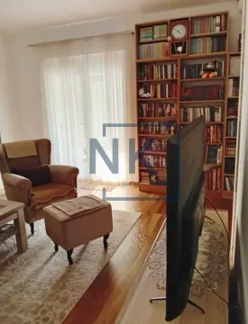 Dnevna soba sa foteljom, policom za knjige i televizorom. - image 3