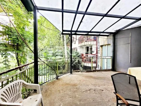Covered terrace with a metal structure and a view of greenery. - image 11