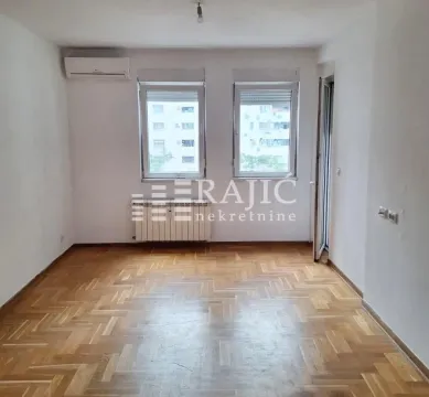 Empty room with parquet flooring and two windows. - image 5
