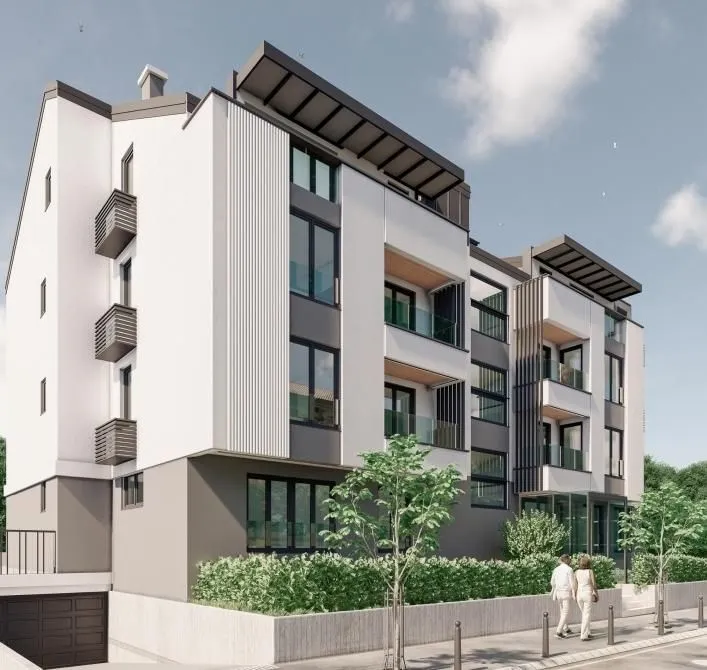 Spoljašnji izgled moderne stambene zgrade sa uređenim dvorištem.