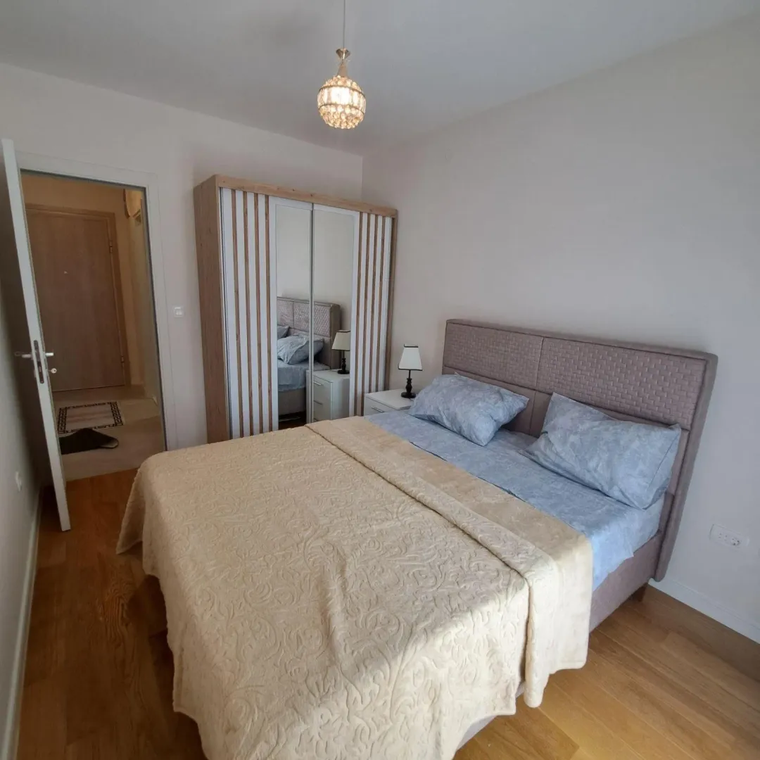 Furnished bedroom with a double bed, wardrobe, and a view of the hallway.