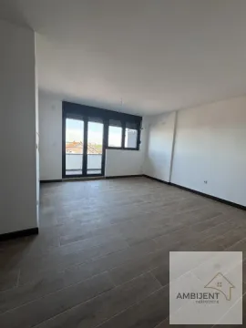 Prazna svetla prostorija sa parketom na podu i balkonskim vratima. - image 3