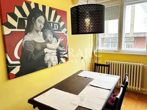 Dining room with a dark wooden table and a large artwork on the wall. - image 10
