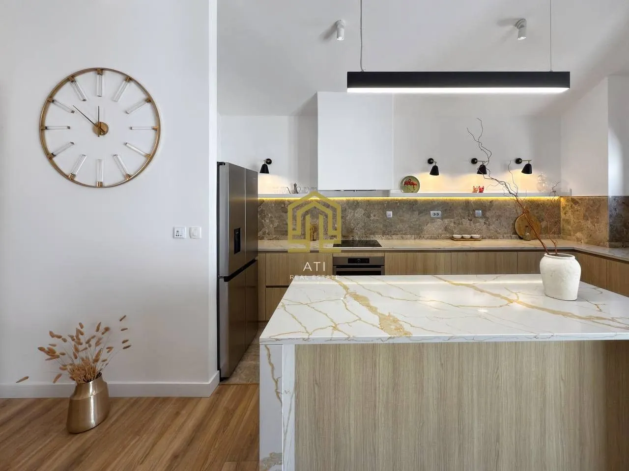Modern kitchen with a marble island and built-in appliances.