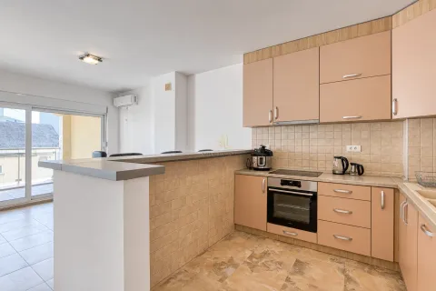 Kitchen with peach-colored cabinets and a breakfast bar separating it from the living area. - image 5