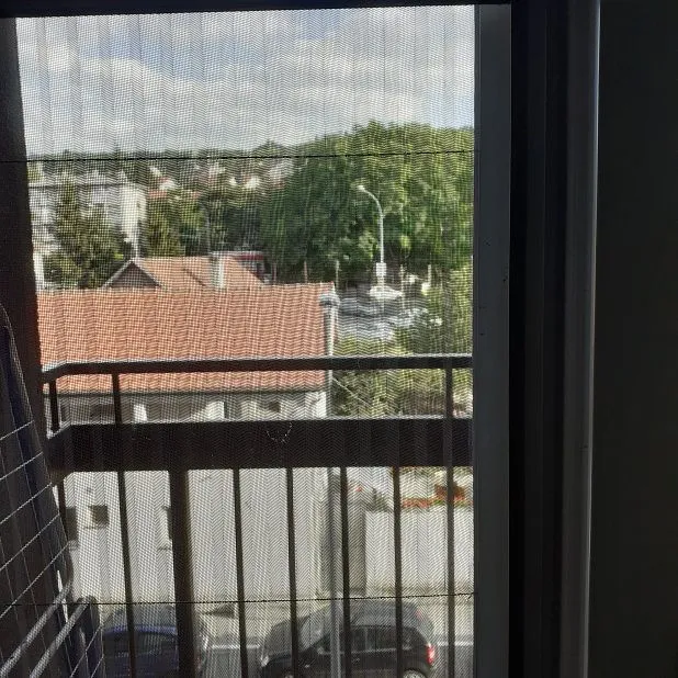 View from the balcony overlooking surrounding buildings and greenery.