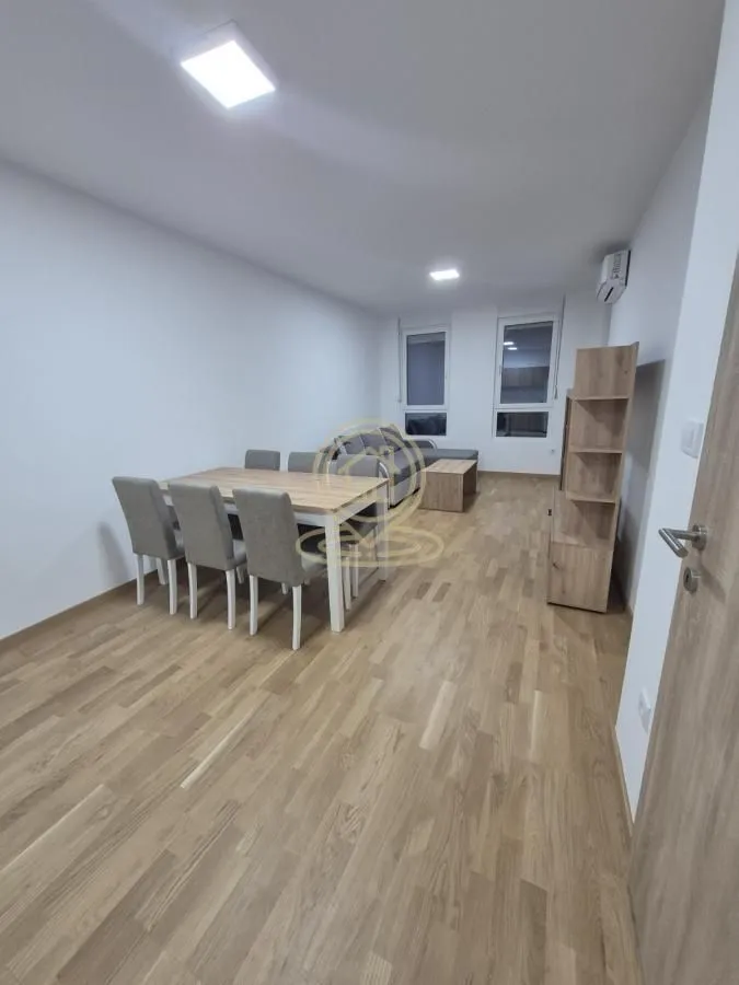 Dnevni boravak sa trpezarijskim stolom i stolicama.