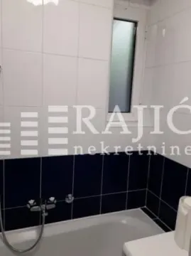 View of the bathroom with a bathtub and white tiles. - image 6