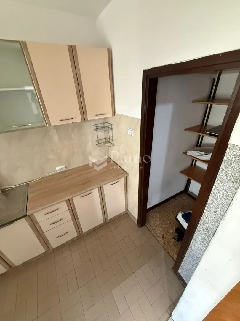 Small kitchen with cabinets and a door leading to a pantry.