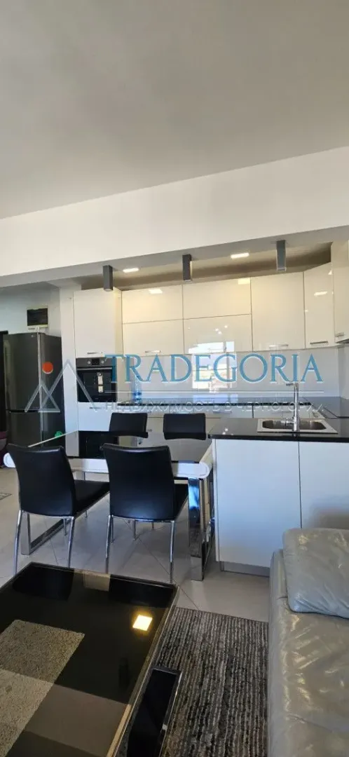 Moderna kuhinja sa trpezarijom i bijelim elementima.