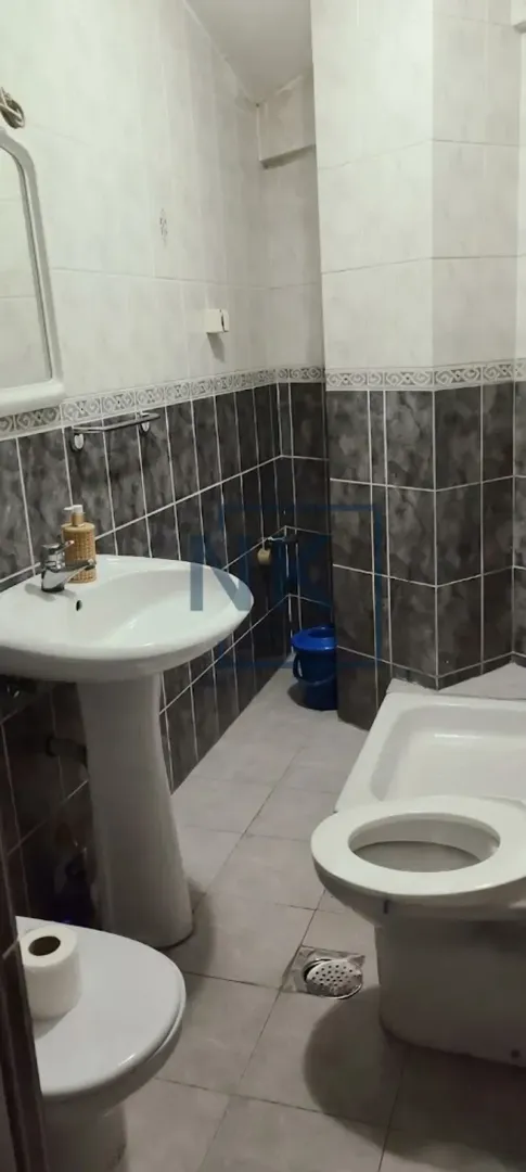 Bathroom equipped with a washbasin, toilet, and ceramic tiles.