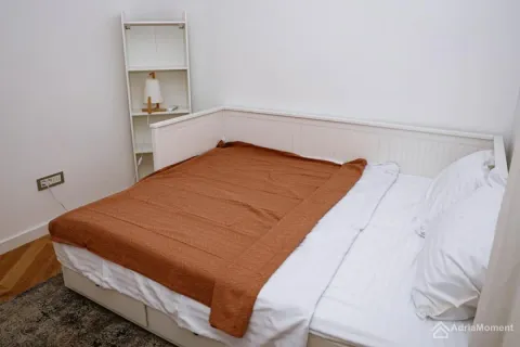 Manja spavaća soba sa krevetom i bijelom police u uglu. - image 6