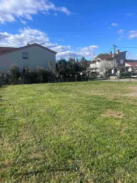 Pogled na prostrano travnato dvorište i okolne kuće. - image 4