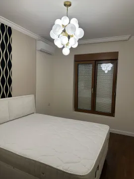 Svijetla spavaća soba sa velikim krevetom i modernim lusterom. - image 4