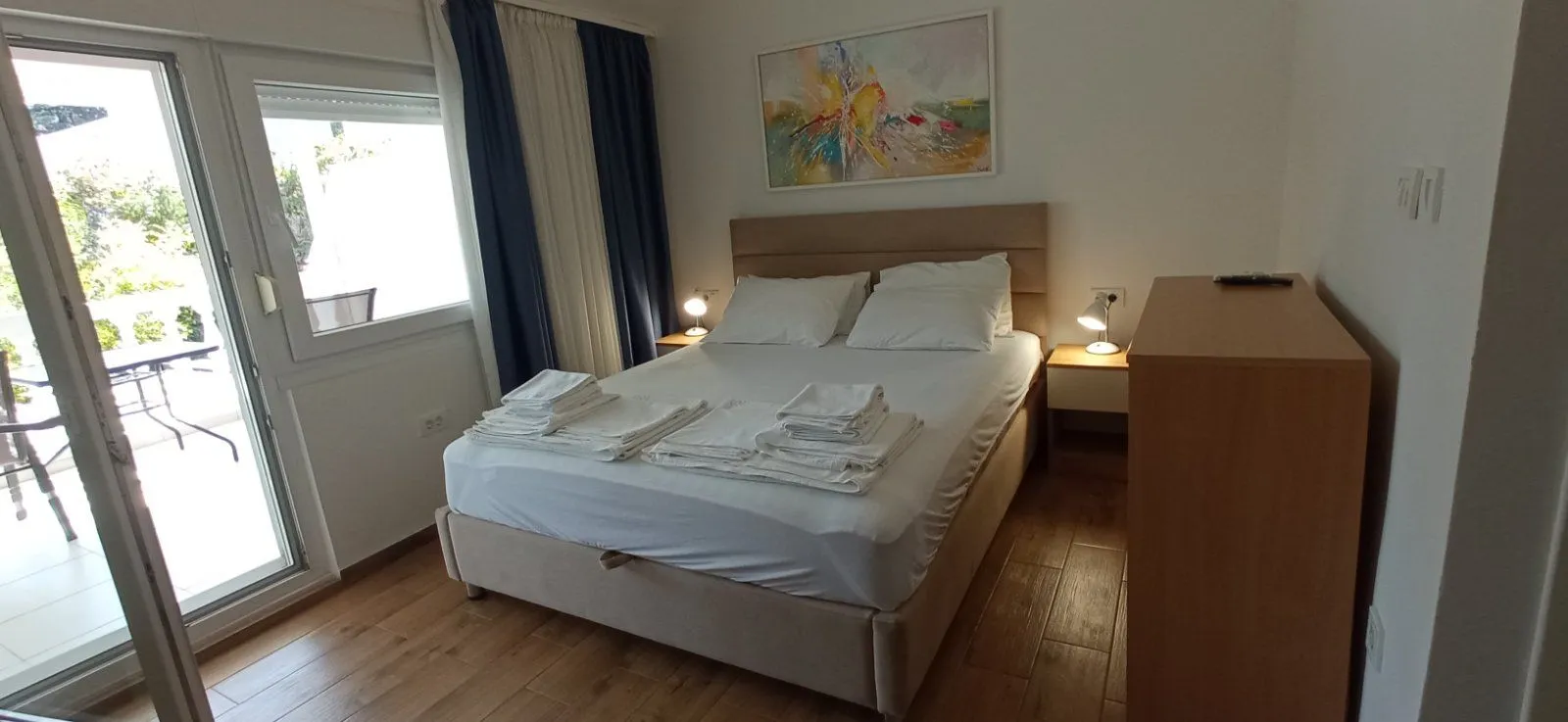 Furnished bedroom with a double bed, bedside lamps, and access to the terrace.