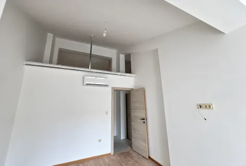 Prazna soba sa bijelim zidovima, klima uređajem i otvorenim vratima. - image 16