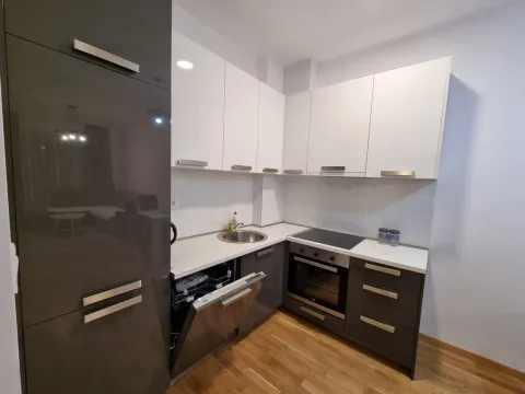 Modern kitchen with white upper cabinets and dark lower cabinets, equipped with built-in appliances. - image 16