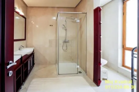 Bathroom with a glass shower cabin, vanity, and wooden elements. - image 10
