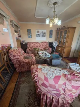 Dnevna soba sa garniturom za sedenje, drvenim nameštajem i lusterom na plafonu. - image 5
