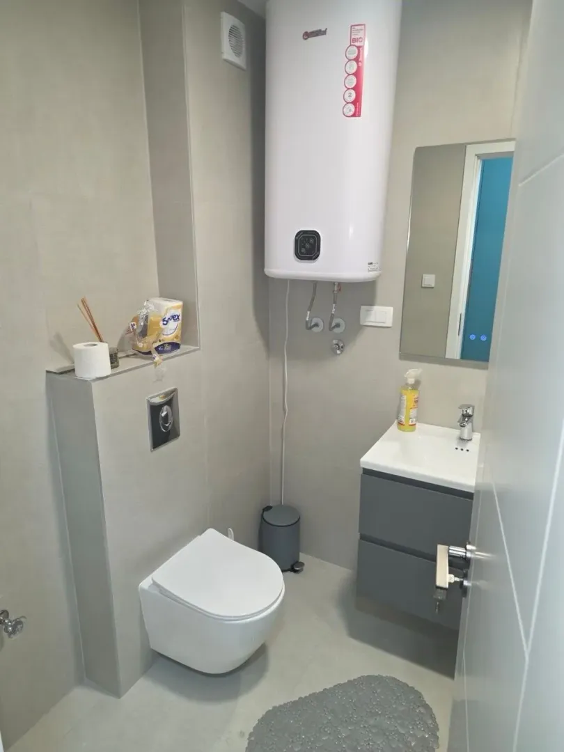 Manje kupatilo sa tuš kabinom, WC šoljom, umivaonikom i bojlerom.