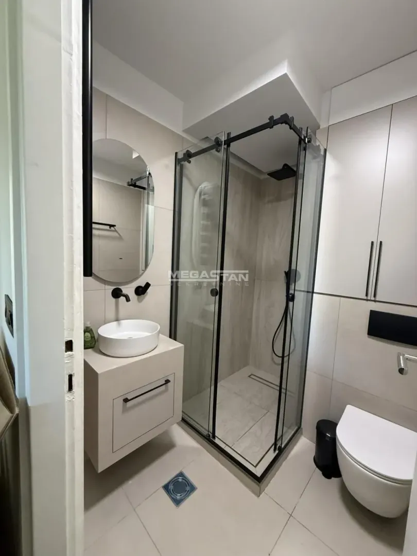 Modern bathroom with a walk-in shower, washbasin, and built-in cabinetry.