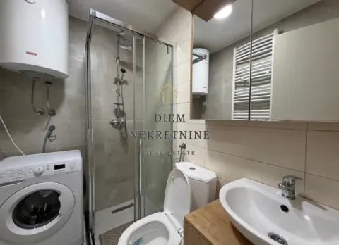 Modern bathroom with a shower cabin, washbasin, toilet, and washing machine. - image 13