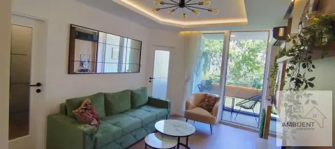Living room with a green sofa, coffee tables, and access to the terrace. - image 9