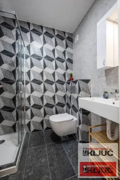Moderno opremljeno kupatilo sa tuš kabinom i keramičkim pločicama sa uzorkom. - image 7