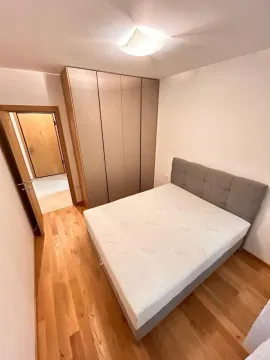 Bright bedroom with a double bed and a large built-in wardrobe. - image 6