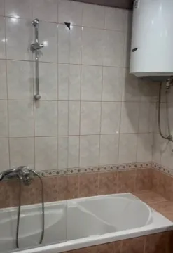 Bathroom with a bathtub and a water heater. - image 12