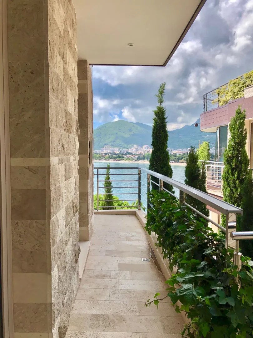 Popločani balkon sa kamenim stubom i predivnim pogledom na more i planine.