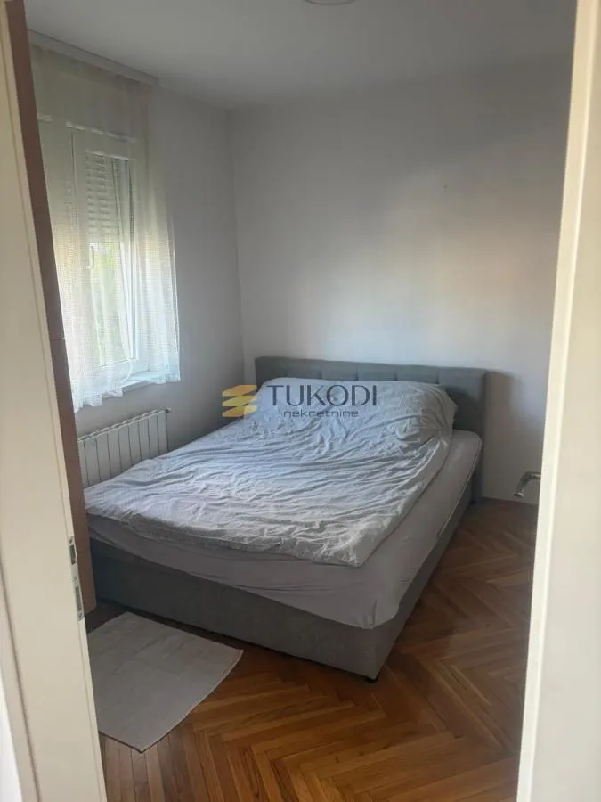 Spavaća soba sa bračnim krevetom i parketom.